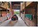 A well-kept barn with high ceilings, stalls, storage, and a lawn mower, offering a practical space at 1555 Mercers Fernery Rd, Deland, FL 32720