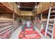 Barn interior featuring wooden stalls, a fan, lattice work, and a lawn mower parked inside at 1555 Mercers Fernery Rd, Deland, FL 32720