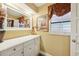 Bathroom featuring a vanity with drawers, a framed mirror, and a decorative valance over the window at 1555 Mercers Fernery Rd, Deland, FL 32720