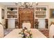 Dining room showcasing brick wall accents, built-in shelving and decorative floral centerpiece at 1555 Mercers Fernery Rd, Deland, FL 32720