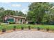 Charming brick house featuring a green lawn, garden and two-car garage for a well-maintained appeal at 1555 Mercers Fernery Rd, Deland, FL 32720