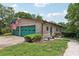 Brick house with a two-car garage and American flag, set against a green lawn and lush trees at 1555 Mercers Fernery Rd, Deland, FL 32720