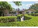 Charming front exterior with a winding pathway through manicured hedges, leading to the front door at 1555 Mercers Fernery Rd, Deland, FL 32720