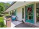 Inviting front porch with seating, plants and a colorful front door that welcomes guests at 1555 Mercers Fernery Rd, Deland, FL 32720