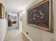 Hallway with neutral color paint, beige carpet, and decorations on the walls to other rooms at 1555 Mercers Fernery Rd, Deland, FL 32720