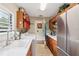 Convenient laundry room with wooden cabinets, stainless fridge, white counters, and tile flooring at 1555 Mercers Fernery Rd, Deland, FL 32720