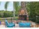 Inviting outdoor fireplace with stone surround, ideal for cozy evenings and gatherings by the well manicured backyard at 1555 Mercers Fernery Rd, Deland, FL 32720