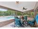 Screened-in patio with comfortable seating, ceiling fan, views of the pool, and outdoor fireplace at 1555 Mercers Fernery Rd, Deland, FL 32720