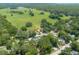 Expansive aerial view of a neighborhood with lush greenery and a large open field in the background at 1620 20Th St, Orange City, FL 32763