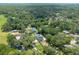 An aerial view of a neighborhood showcases lush green trees and well-spaced homes at 1620 20Th St, Orange City, FL 32763