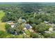 High angle showcases a property nestled among trees, featuring a private pool and well-kept gardens at 1620 20Th St, Orange City, FL 32763
