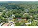 Aerial view of a property with a well-maintained lawn, swimming pool, garden, and surrounding mature trees at 1620 20Th St, Orange City, FL 32763