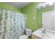 Bright bathroom featuring leaf patterned shower curtain, a new toilet and a mirror at 1725 12Th St, Orange City, FL 32763