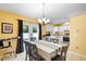 Inviting dining area with modern chandelier, dining table, and adjacent kitchen enhancing the home's appeal at 1725 12Th St, Orange City, FL 32763