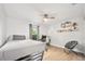 Cozy bedroom with modern decor, featuring wood-look floors, a ceiling fan, and a comfortable bed at 1734 Magnolia Ave, Deland, FL 32724