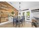 Stylish dining area featuring a wooden accent wall, modern lighting, and a view of the backyard at 1734 Magnolia Ave, Deland, FL 32724