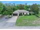Beautiful single-story home with a well-manicured lawn, mature trees, and a two-car garage at 1734 Magnolia Ave, Deland, FL 32724
