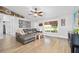 Comfortable living room featuring a grey leather couch, a large window and bright hard wood floors at 1734 Magnolia Ave, Deland, FL 32724