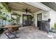 Inviting covered patio featuring a ceiling fan, dining set, and grill, perfect for outdoor entertaining at 1734 Magnolia Ave, Deland, FL 32724