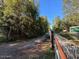 View of property from the dirt road, with the home, an outbuilding and a fence with US flags at 17531 Ne 139Th Ave, Fort Mc Coy, FL 32134
