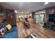Open living room features wooden walls, a blue sofa, hardwood floors, and natural light at 17531 Ne 139Th Ave, Fort Mc Coy, FL 32134