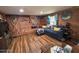 Cozy living room with a wooden accent wall, hardwood floors, natural light, and comfortable seating at 17531 Ne 139Th Ave, Fort Mc Coy, FL 32134