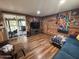 Bright living room features hardwood floors, a wooden accent wall, comfortable seating, and lots of natural light at 17531 Ne 139Th Ave, Fort Mc Coy, FL 32134