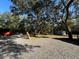 View of the gravel drive and yard, with trees and a storage shed at 17531 Ne 139Th Ave, Fort Mc Coy, FL 32134