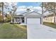 Charming one-story home with a well-manicured lawn, gray paint, and a two-car garage at 1856 9Th Ave, Deland, FL 32724