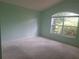 Inviting bedroom with light green walls, neutral carpet, and arched window at 2051 Sherwood Forest Dr, Orange City, FL 32763