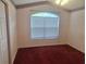 Bright bedroom with a large window, red carpet, and a ceiling fan at 2051 Sherwood Forest Dr, Orange City, FL 32763