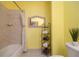 Bright bathroom with tiled shower, decorative mirror and shelving for storage at 208 Wall St # 204, Daytona Beach, FL 32114