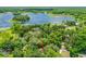 Aerial view showcases a secluded home nestled among mature trees near a beautiful lake at 2163 Fireside Rd, Deltona, FL 32738