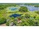 Breathtaking aerial view of a home nestled among lush greenery, with a lake adding to the scenic backdrop at 2163 Fireside Rd, Deltona, FL 32738