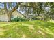 Lush backyard with views of a tranquil pond, shaded by a large tree at 2163 Fireside Rd, Deltona, FL 32738