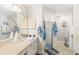 Well-lit bathroom with tiled countertop, framed mirror, and a glass-enclosed shower at 2163 Fireside Rd, Deltona, FL 32738