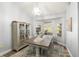 Bright dining room with a stylish table, elegant chandelier, and large windows with a view of the trees at 2163 Fireside Rd, Deltona, FL 32738