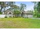 Charming home featuring a well-manicured lawn, mature landscaping, and an attached garage at 2163 Fireside Rd, Deltona, FL 32738