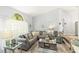 Bright living room featuring a large gray sectional, stylish decor, and a window showcasing a view of the trees at 2163 Fireside Rd, Deltona, FL 32738