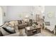 Elegant living room with a comfortable gray sectional, decorative pillows, wood flooring, and an open archway at 2163 Fireside Rd, Deltona, FL 32738