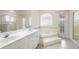 Bright bathroom featuring double sinks, a soaking tub, and natural light at 2478 Unionville Dr, Deltona, FL 32725