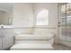 Bathroom showcasing a soaking tub with tiled accents and a large window at 2478 Unionville Dr, Deltona, FL 32725