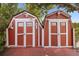 Two backyard sheds with red siding and white trim, providing ample storage space at 2478 Unionville Dr, Deltona, FL 32725