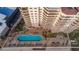 Aerial view of a condo's pool deck and lounge area, with seating, a pool, and landscaping at 2515 S Atlantic Ave # 203, Daytona Beach, FL 32118