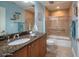 Bathroom with granite counters, tan walls, and a glass shower-tub combo at 2515 S Atlantic Ave # 203, Daytona Beach, FL 32118