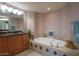 Relaxing bathroom with soaking tub, wood cabinets, and ample counter space at 2515 S Atlantic Ave # 203, Daytona Beach, FL 32118