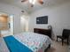 Bright bedroom featuring a ceiling fan, TV, dresser, chair, and access to an ensuite bathroom at 2515 S Atlantic Ave # 203, Daytona Beach, FL 32118