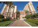 Beautiful condo building with lush landscaping and a circular driveway under a clear blue sky at 2515 S Atlantic Ave # 203, Daytona Beach, FL 32118