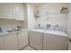 Laundry room featuring washer, dryer, utility sink, white cabinets, and shelving at 2515 S Atlantic Ave # 203, Daytona Beach, FL 32118