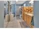 Well-lit bathroom with double sinks, a glass-enclosed shower, and white tile flooring at 2676 Palm Terrace St, Deland, FL 32720